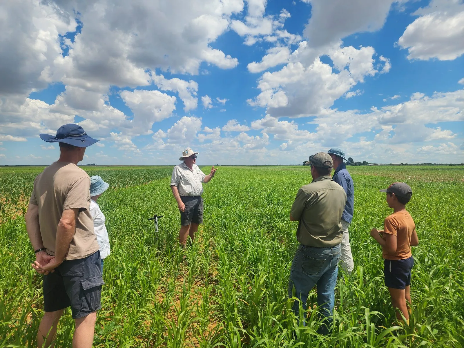 A DRIS agronomist explaining crop nutrition to a group in a green field