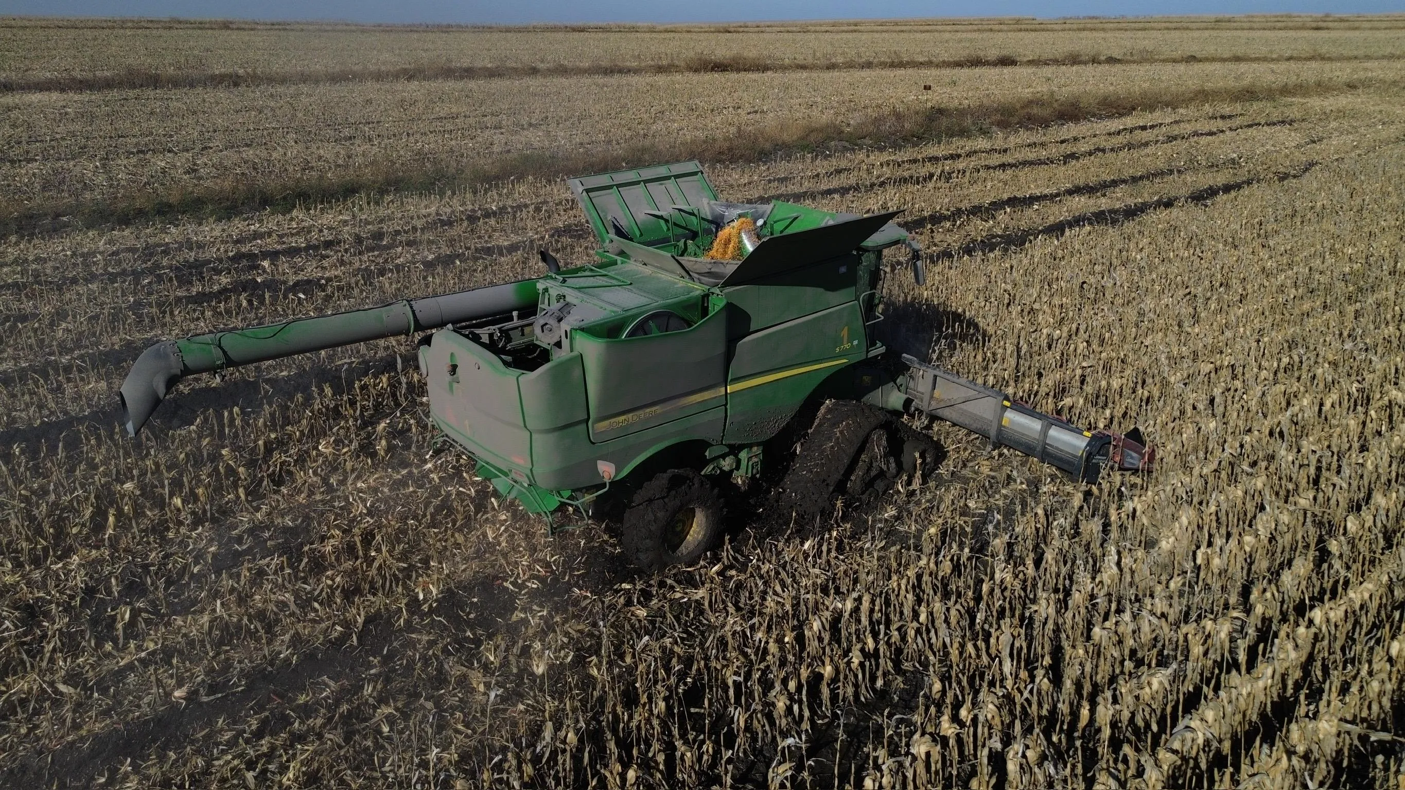 Combine harvester offloading maize in a monitored field