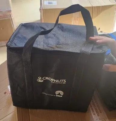 Insulated CROPNUTS cooler bag packed on shipping boxes, ready to send